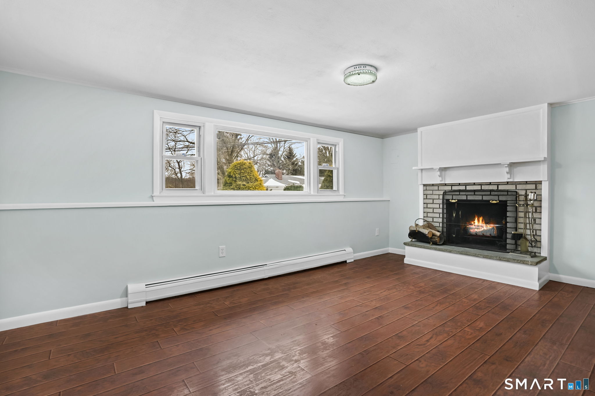 25 Fairchild Road Stratford, CT 06614 - Photo 25 of 40 an empty room with windows fireplace and wooden floor