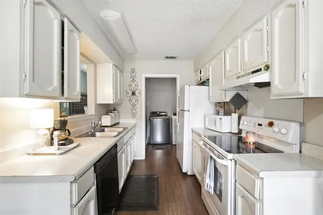 a kitchen with stainless steel appliances a sink a stove a refrigerator and cabinets