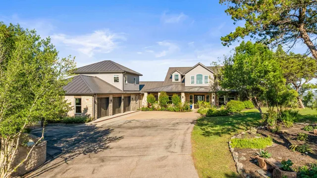 a front view of a house with a yard and trees