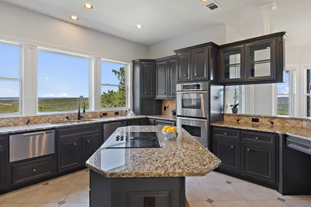 a kitchen with granite countertop a sink and cabinets