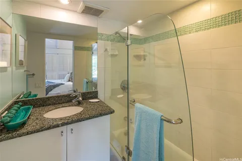 a bathroom with a shower sink vanity granite and mirror