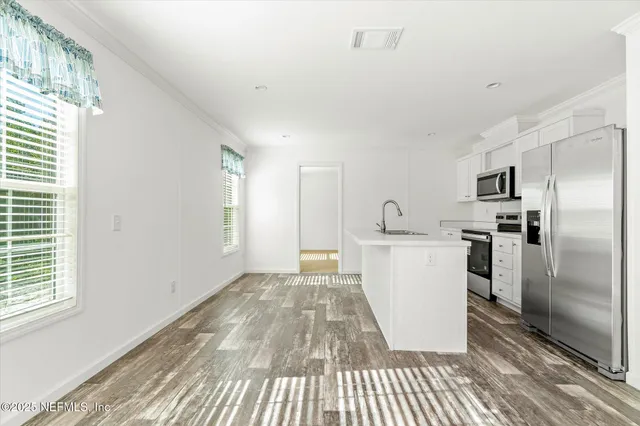 a kitchen with stainless steel appliances a refrigerator sink and microwave