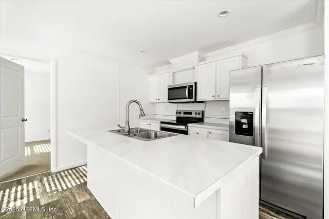 a kitchen with stainless steel appliances a stove a microwave and white cabinets
