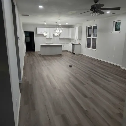 a view of a hallway with wooden floor and entryway