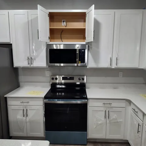 a kitchen with cabinets appliances a sink and a window