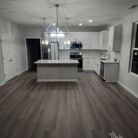 a kitchen with white cabinets and black appliances