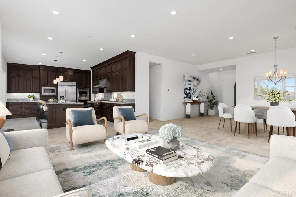 a living room with furniture kitchen view and a wooden floor