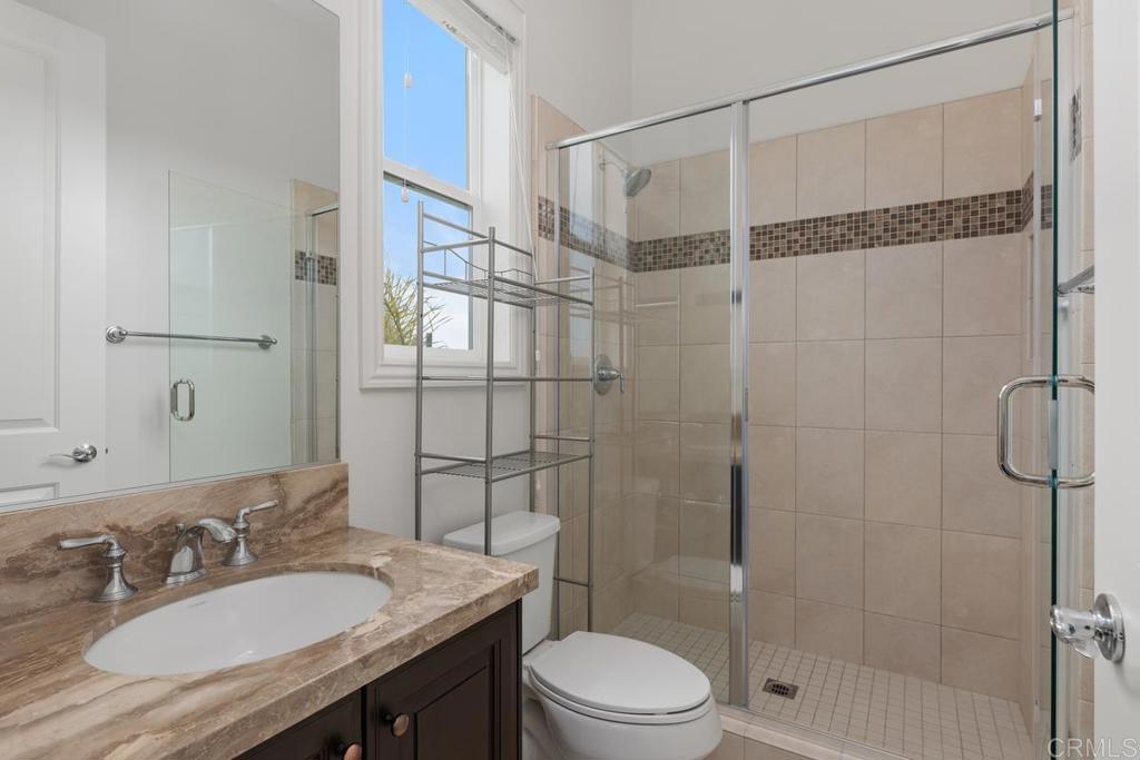 2527 Wellspring Street Carlsbad, CA 92010 - Photo 23 of 28 a bathroom with a sink toilet a mirror and shower