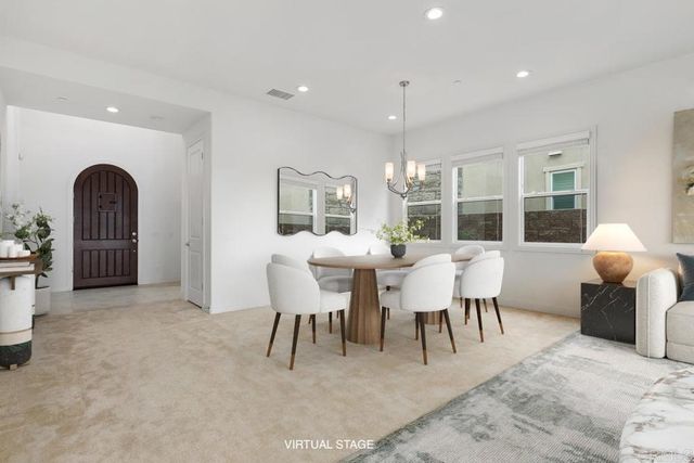 a view of a dining room with furniture and chandelier