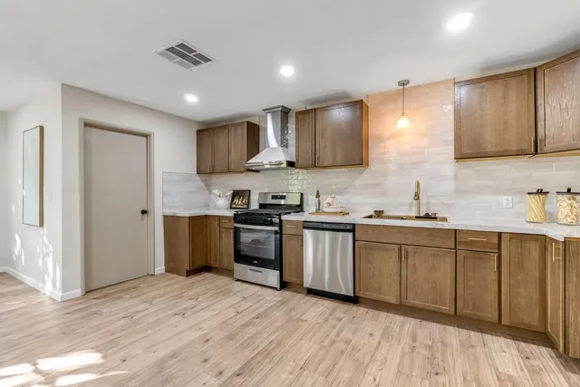 a kitchen with granite countertop a sink cabinets and stainless steel appliances
