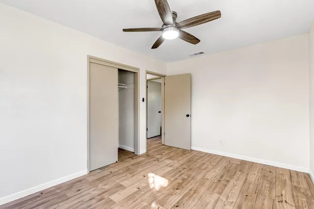a view of a big room with wooden floor and a ceiling fan