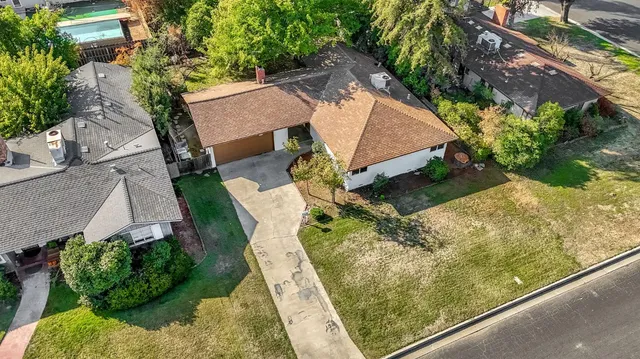 an aerial view of a house with a yard and potted plants