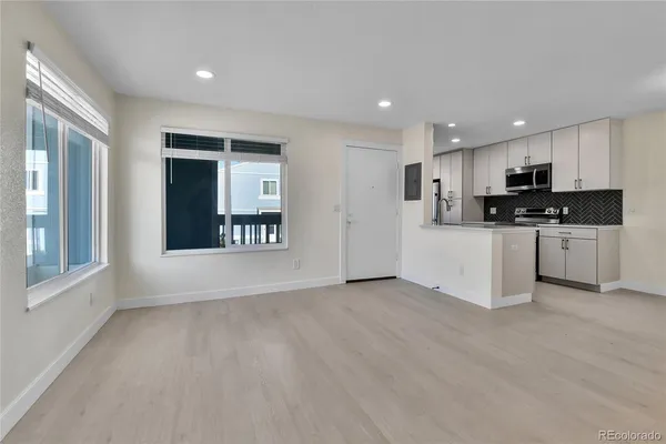 a view of a kitchen with a sink a microwave and cabinets