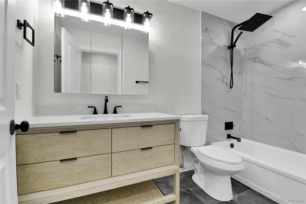 a bathroom with a sink vanity mirror and toilet