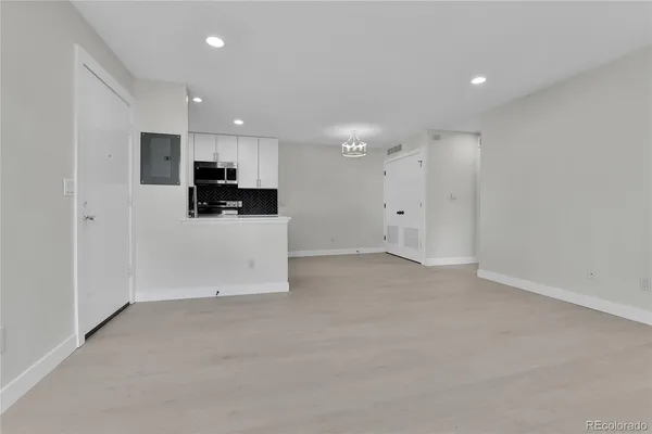 a view of a kitchen with a sink and a refrigerator in a room