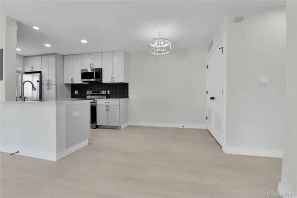 a kitchen with stainless steel appliances granite countertop a stove top oven a sink a refrigerator and a refrigerator