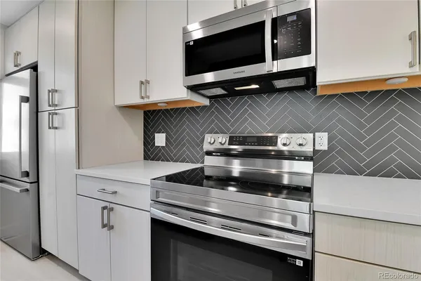 a kitchen with stainless steel appliances a stove and a microwave