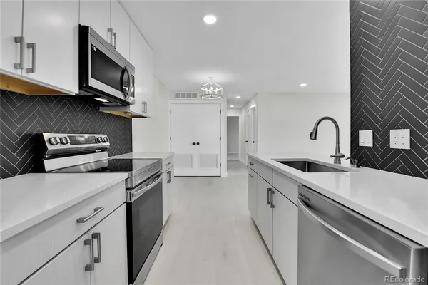 a kitchen with stainless steel appliances granite countertop a sink stove and microwave