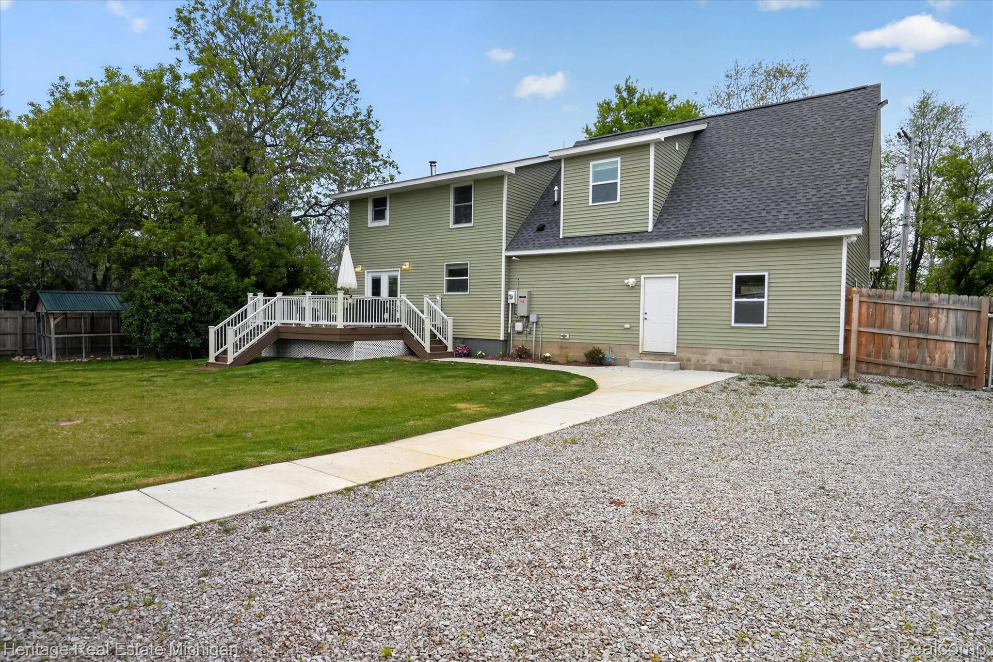 5835 Warner Road Fowlerville, MI 48836 - Photo 43 of 59 Rear view of house featuring a fenced backyard, roof with shingles, and a deck