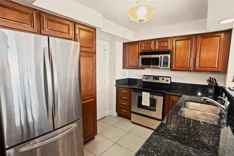 a kitchen with stainless steel appliances granite countertop a refrigerator stove and sink