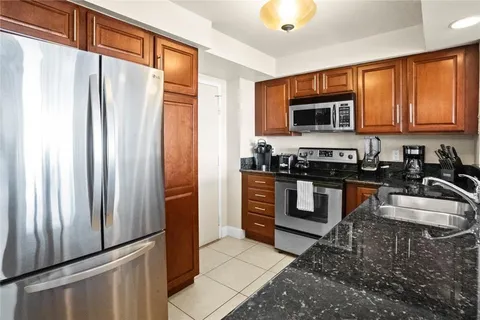 a kitchen with stainless steel appliances granite countertop a sink stove and cabinets