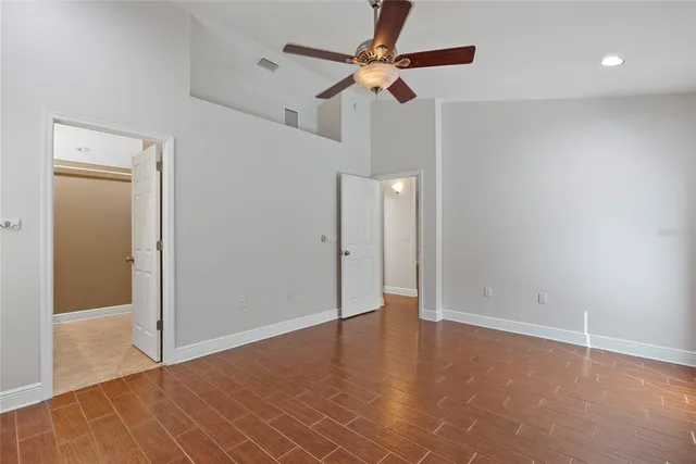 an empty room with closet and a chandelier fan
