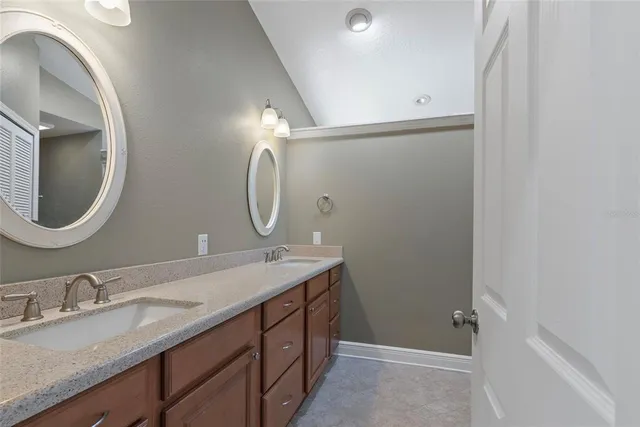 a bathroom with a granite countertop sink a mirror and a vanity