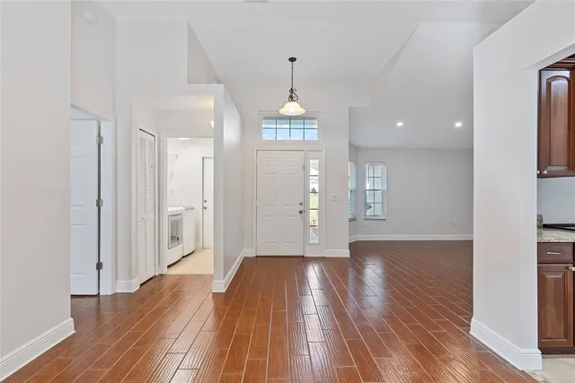 a view of a room with wooden floor staircase and a kitchen