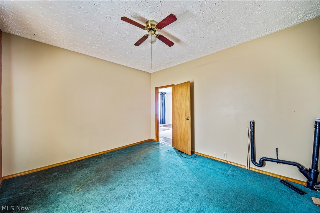 116 South Cedar Street Geneva, OH 44041 - Photo 14 of 35 First floor Carpeted bedroom with ceiling fan and a textured ceiling, laundry hook up