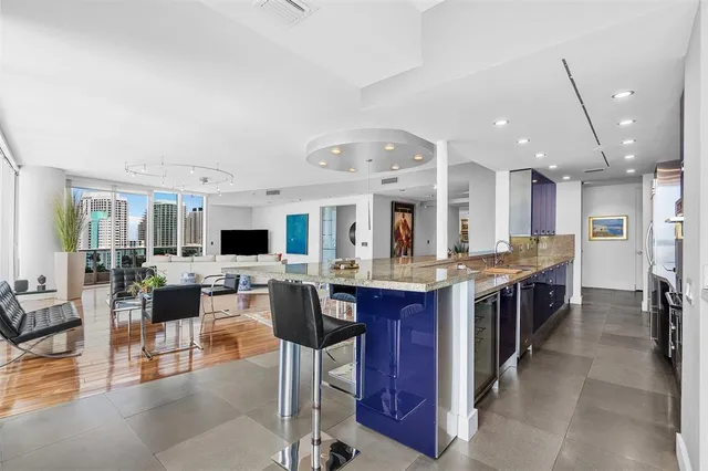 a kitchen with kitchen island a counter top space a sink stainless steel appliances and cabinets