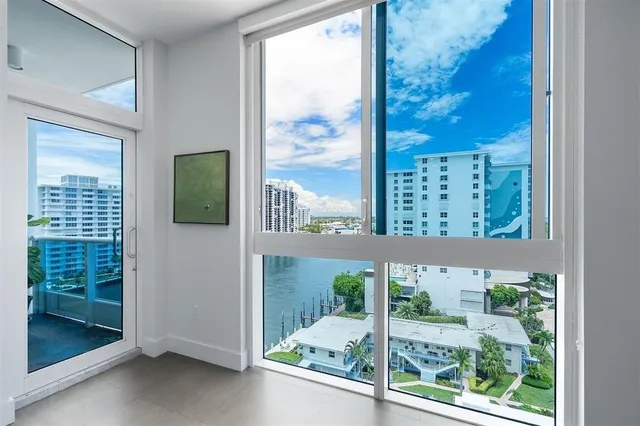 an aerial view of a city with lots of residential buildings ocean and mountain view in back