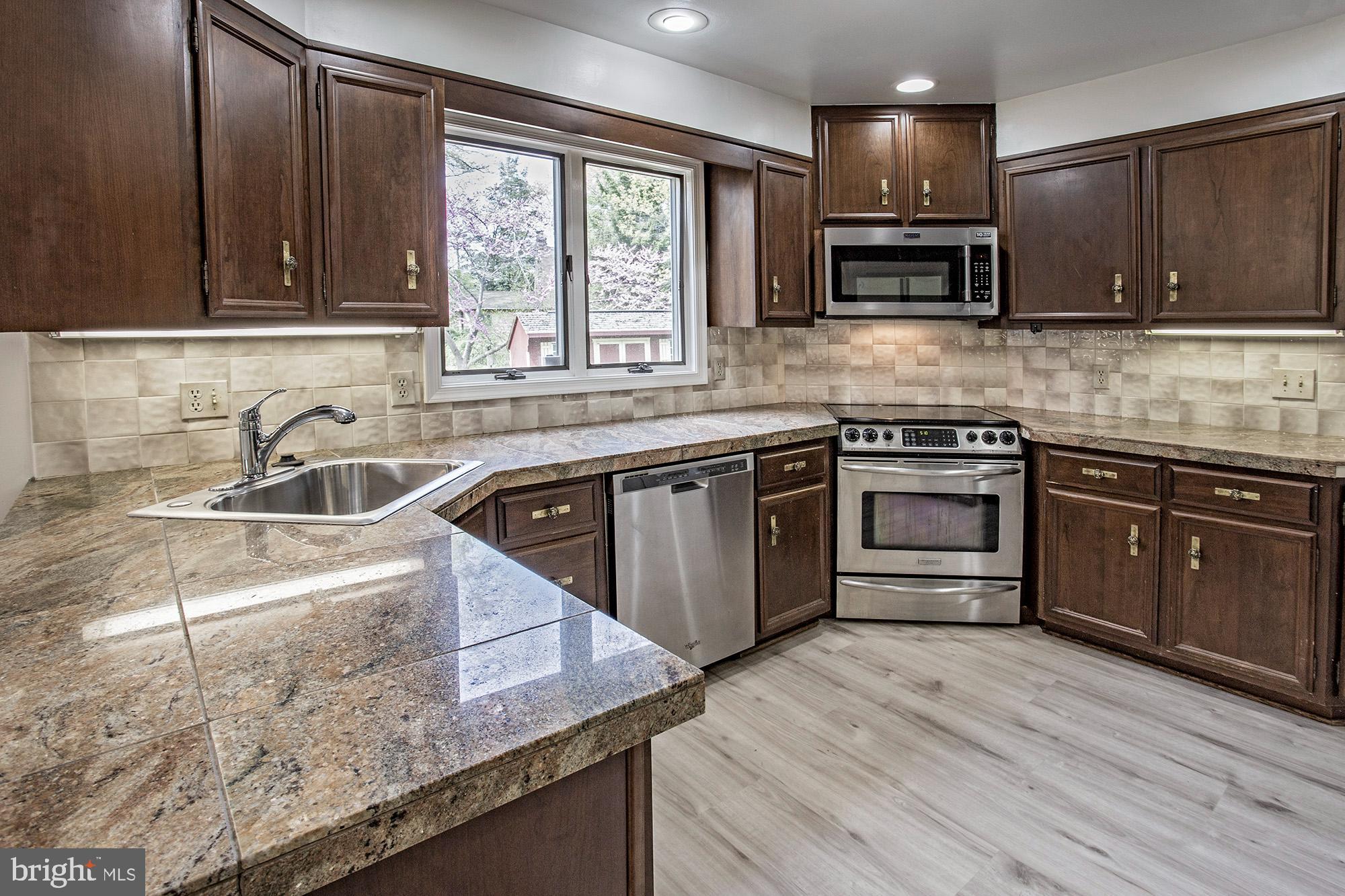 1139 Webster Drive Wilmington, DE 19803 - Photo 13 of 37 a kitchen with stainless steel appliances granite countertop wooden cabinets a sink and a stove