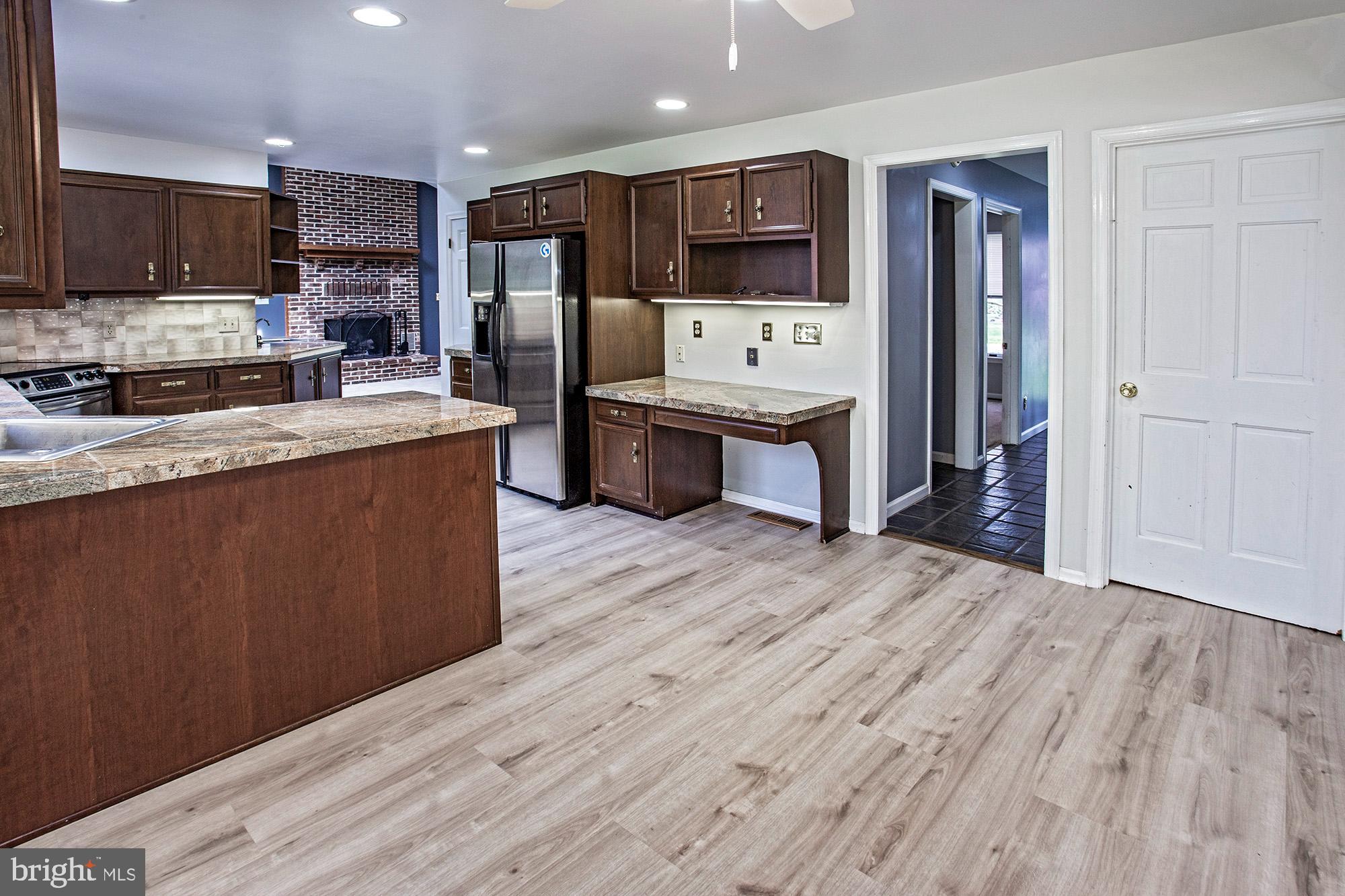 1139 Webster Drive Wilmington, DE 19803 - Photo 14 of 37 a large kitchen with stainless steel appliances wooden floors and wooden cabinets
