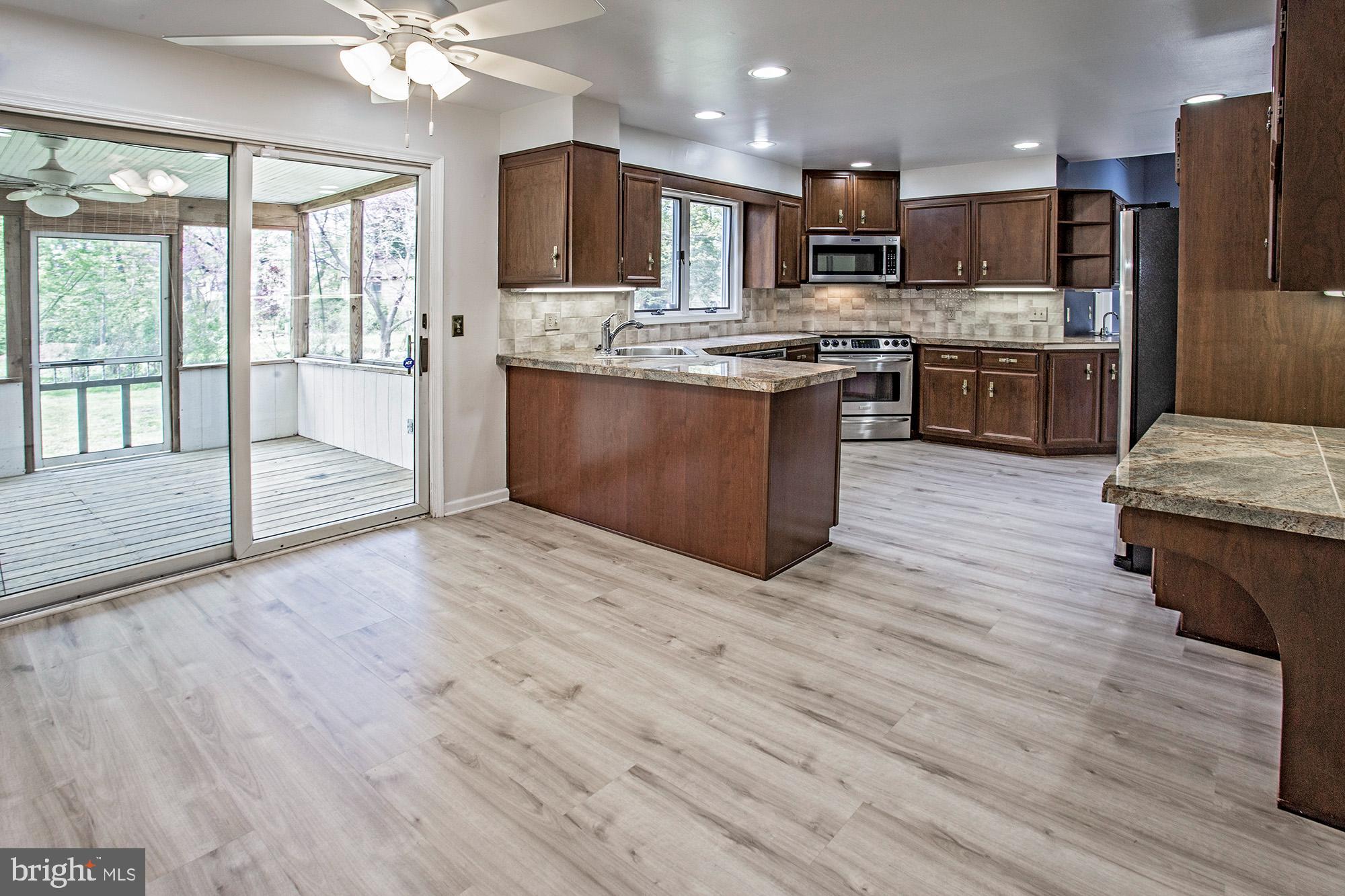 1139 Webster Drive Wilmington, DE 19803 - Photo 15 of 37 a large kitchen with stainless steel appliances wooden floor and a view of living room