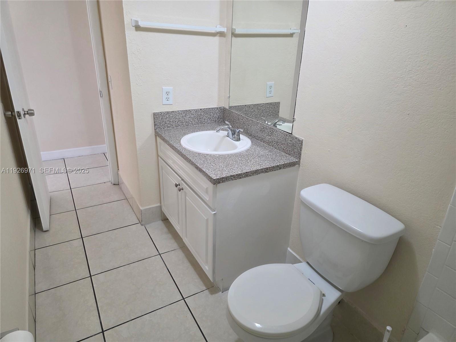 4400 West 16th Avenue, Unit 630 Hialeah, FL 33012 - Photo 15 of 34 a bathroom with a granite countertop toilet sink and mirror