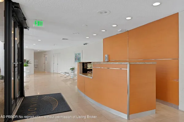 a living room with stainless steel appliances furniture a rug and a kitchen view