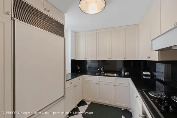 a kitchen with a sink a stove and cabinets