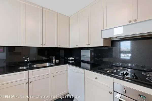 a kitchen with granite countertop white cabinets and black appliances