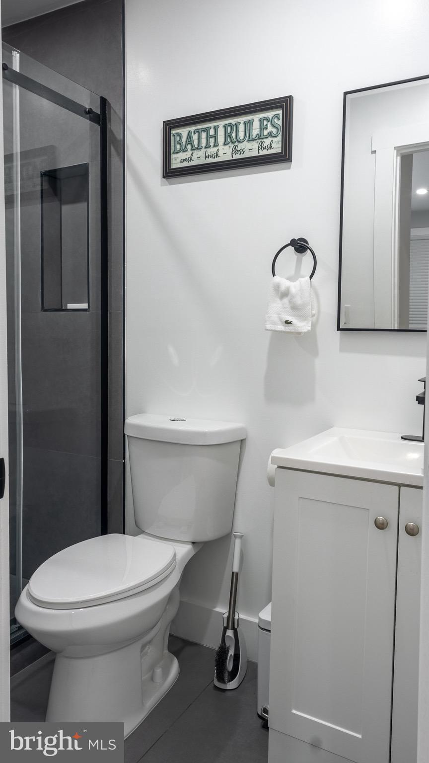 37 4th Street Laurel, MD 20707 - Photo 14 of 26 a white toilet sitting next to a bathroom sink