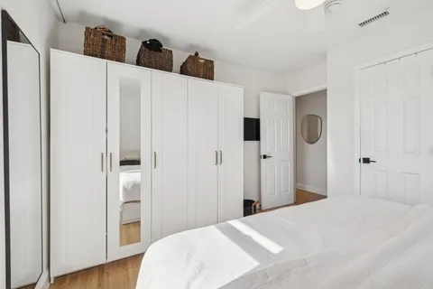 a bedroom with a bed and wooden floor