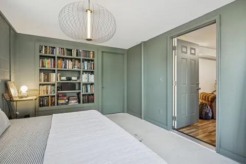 a bedroom with a bed and a book shelf