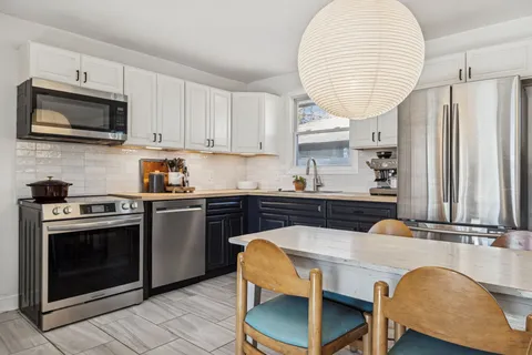 a kitchen with stainless steel appliances a stove a sink and a microwave