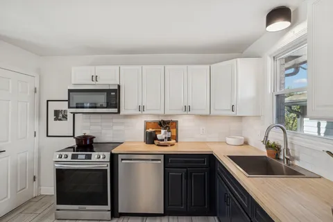 a kitchen with sink a microwave and cabinets