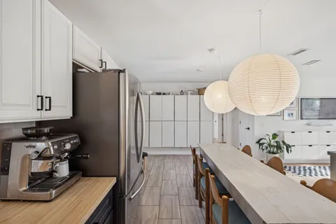 a kitchen with granite countertop a white cabinets stainless steel appliances and a wooden floor