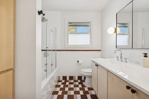 a bathroom with a sink a toilet and a mirror