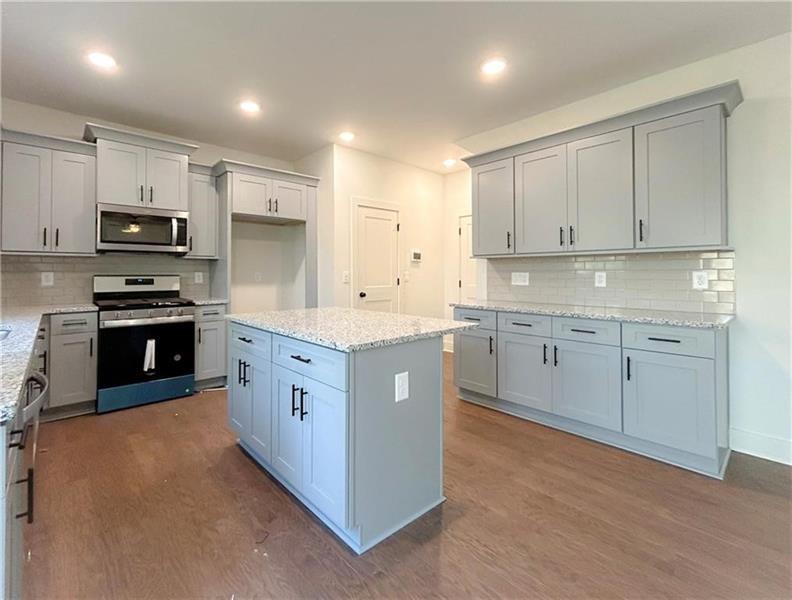 27 Bridgestone Way Cartersville, GA 30120 - Photo 8 of 31 a kitchen with stainless steel appliances granite countertop a stove a sink a refrigerator and white cabinets