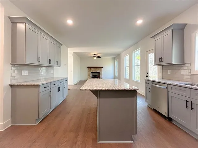 a kitchen with granite countertop a sink stove and cabinets