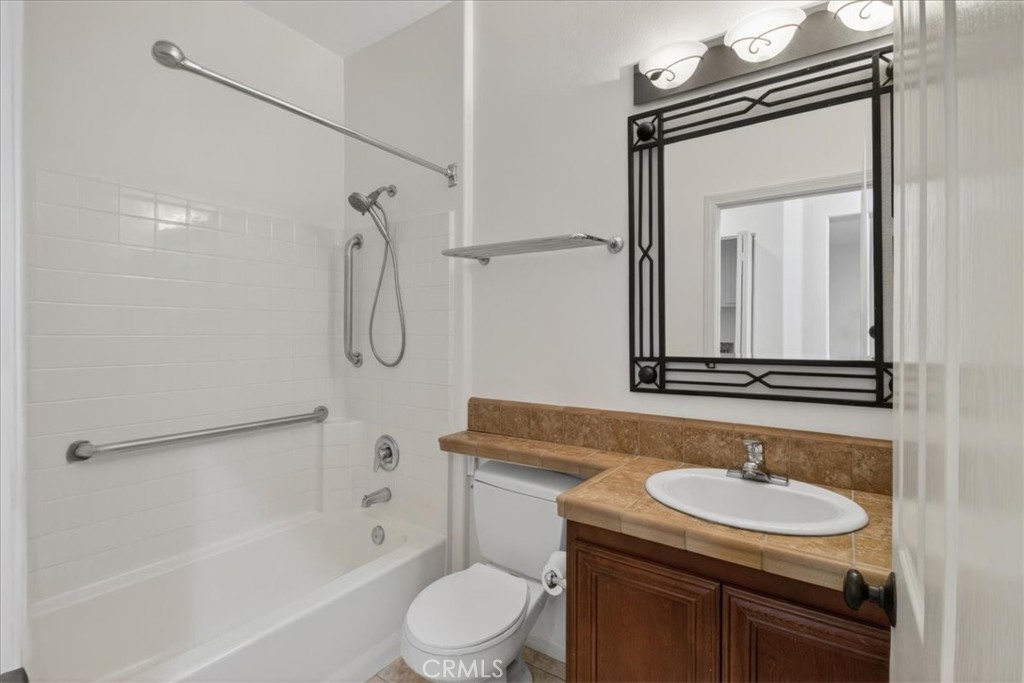 19266 Scripts Court Huntington Beach, CA 92648 - Photo 21 of 47 a bathroom with a granite countertop sink toilet a mirror and shower