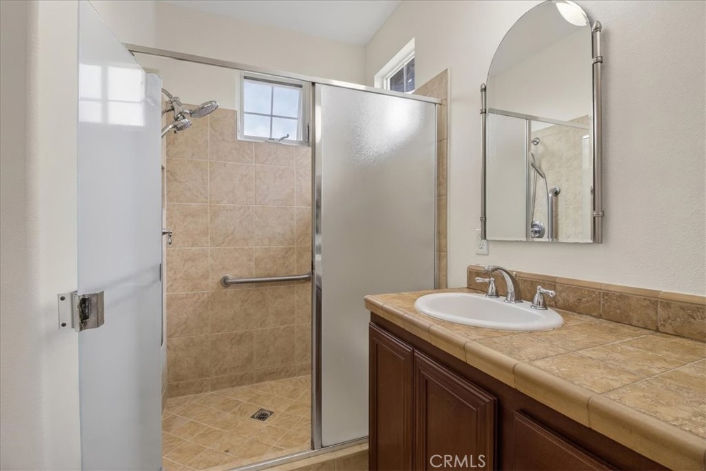19266 Scripts Court Huntington Beach, CA 92648 - Photo 30 of 47 a bathroom with a granite countertop shower sink and mirror