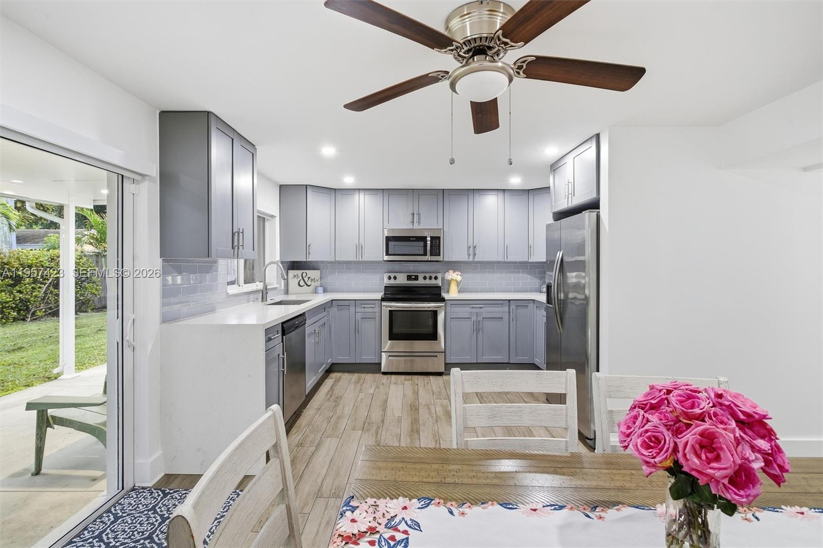 941 East 16th Place Hialeah, FL 33010 - Photo 11 of 32 a kitchen with kitchen island granite countertop a sink stainless steel appliances cabinets and a counter top space